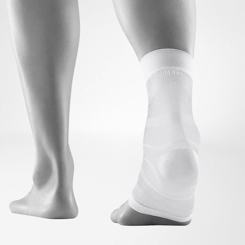 Person wearing a compression ankle brace for injury support and pain relief.