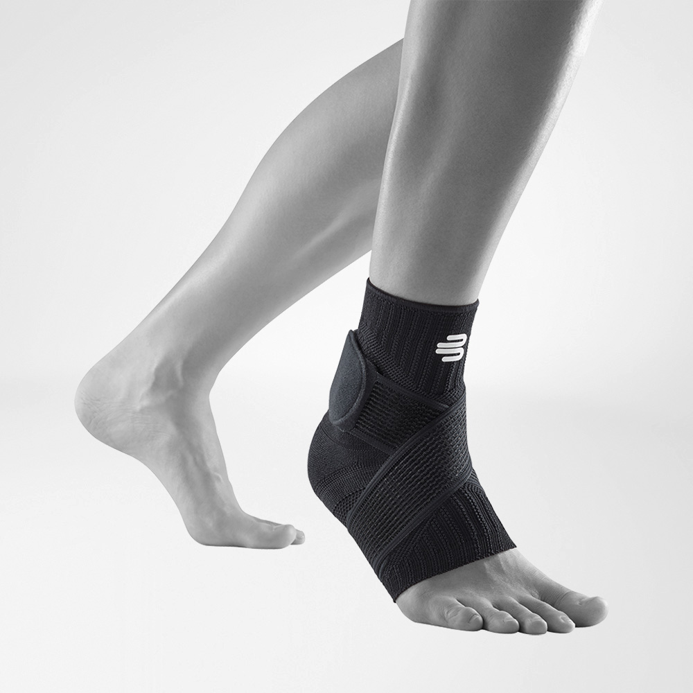 Front-side view of the Sports Ankle Support all black on a grey foot