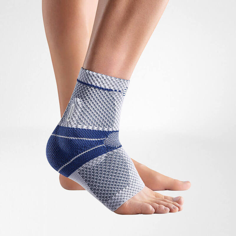 High-Quality Ankle Brace for Injury Support and Recovery Close-up view of a blue and gray ankle support brace on a person's left foot against a white background