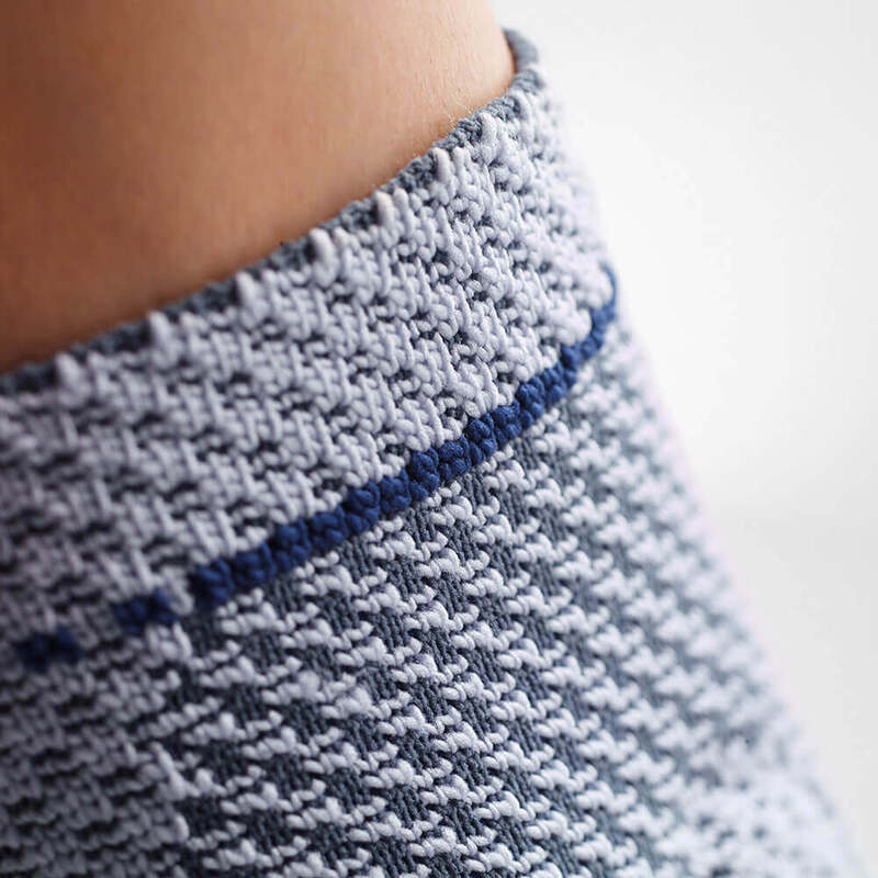 Detailed Knitted Sweater Texture with Stylish Blue Stripe Close-up view of a knitted sweater with detailed texture and a ribbed collar featuring a blue stripe