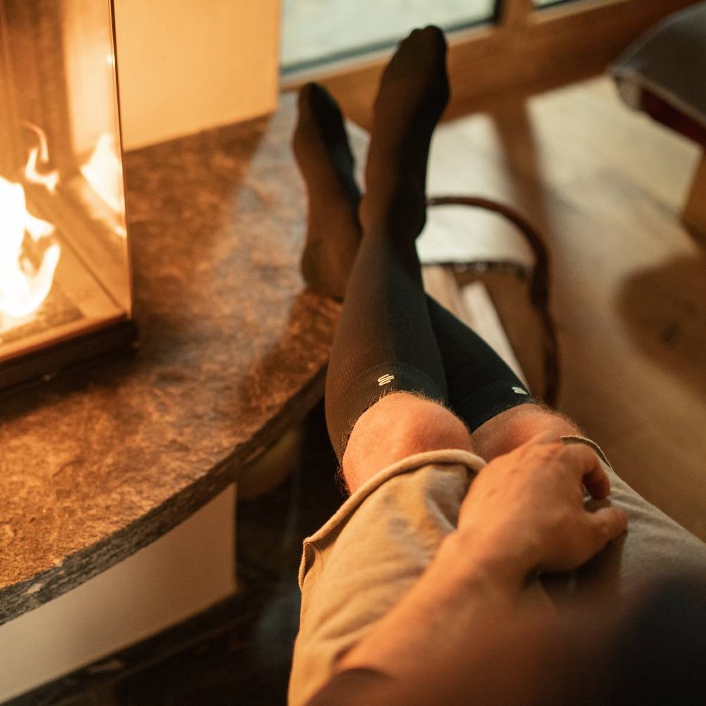 Relaxing by the Fireplace with Black Socks | Cozy Home Moments Person relaxing by a cozy fireplace with feet up, wearing black socks.