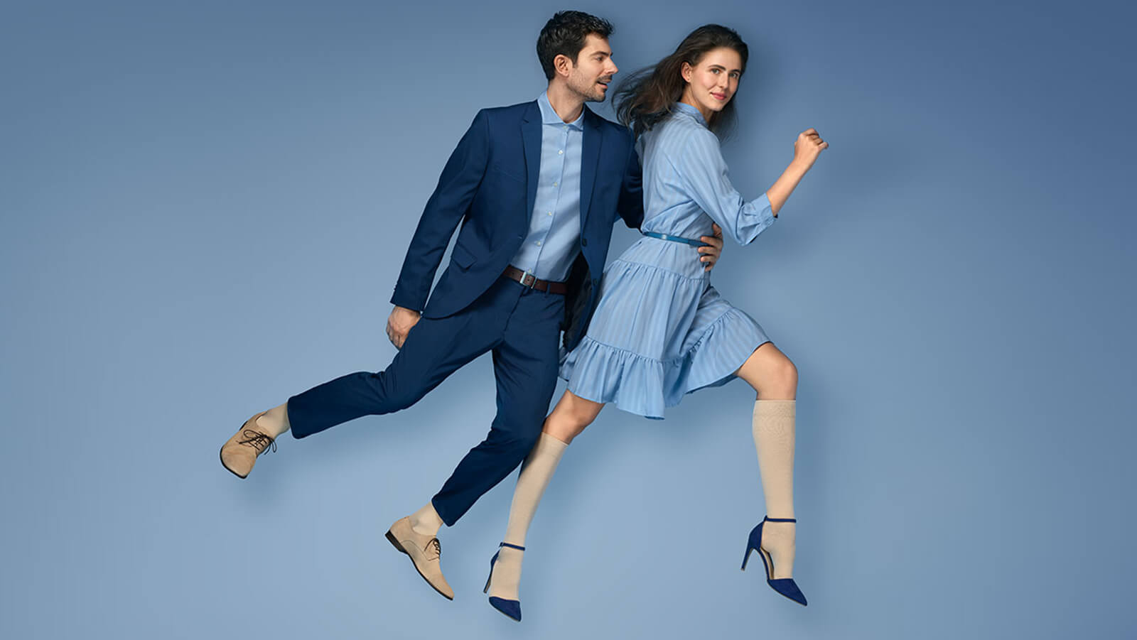Professionally dressed man and woman wearing the VenoTrain micro Compression Stockings. Professionally dressed man and woman wearing Bauerfeind's VenoTrain micro Compression Stockings.