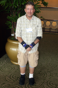 David Griggs smiling for a photo while wearing Bauerfeind's ManuTrain wrist braces and GenuTrain knee braces.