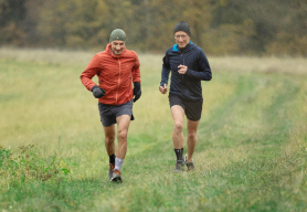 Two men wearing Bauerfeind's AchilloTrain Achilles tendonitis ankle brace while running.