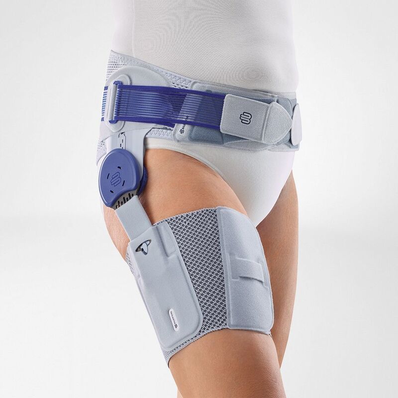 Close-up view of a person wearing an advanced knee brace featuring adjustable straps and a mechanical joint stabilizer on a white background.