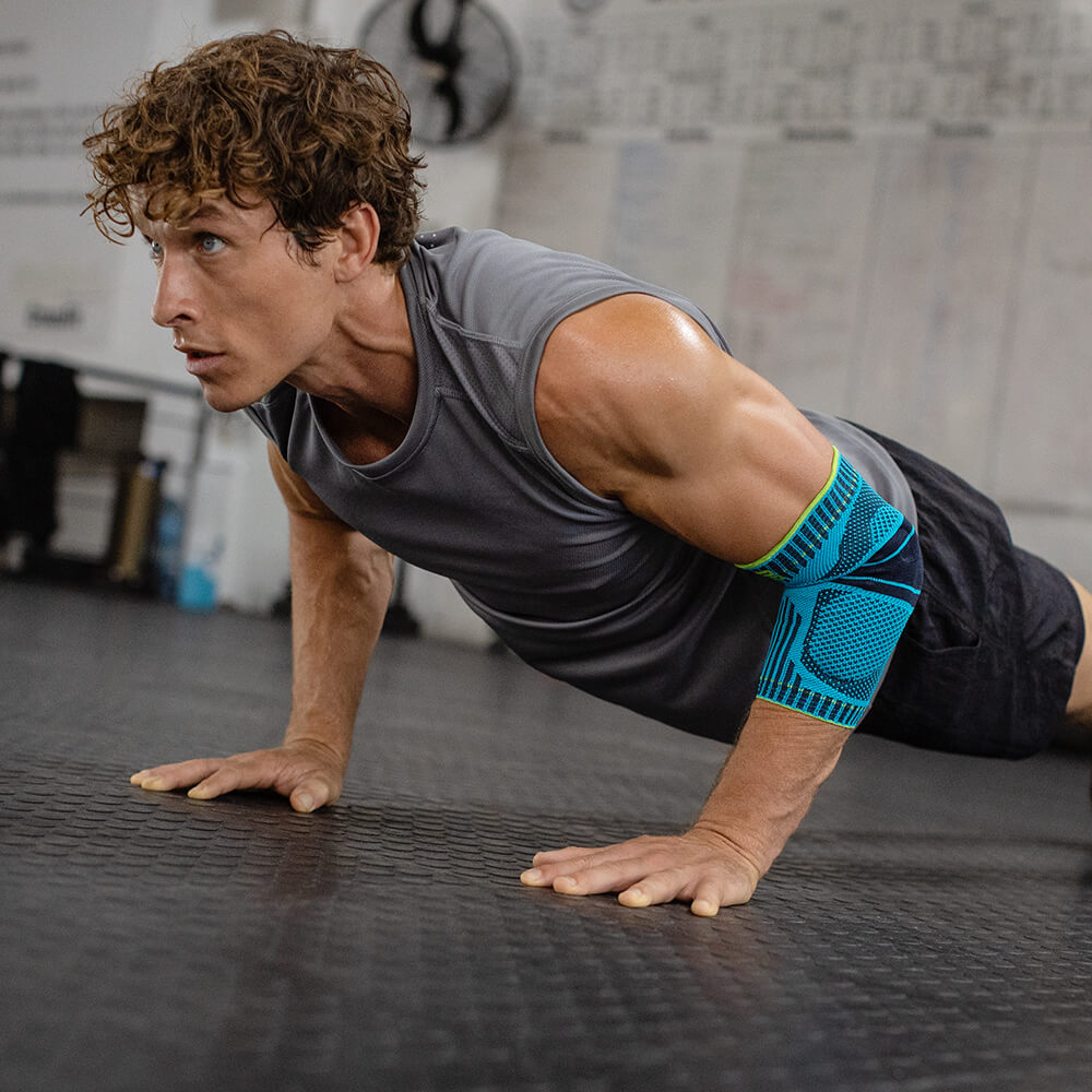 Man working out with Sports Elbow Support Man working out with Sports Elbow Support