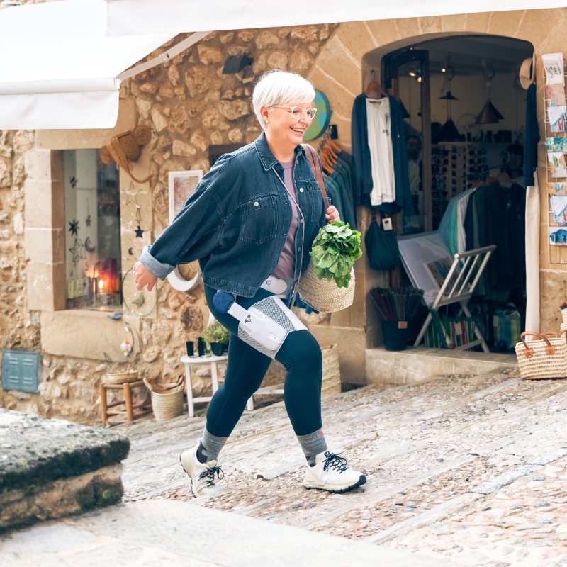 Woman wears Bauerfeind's CoxaTrain osteoarthritis hip brace for pain relief and support.