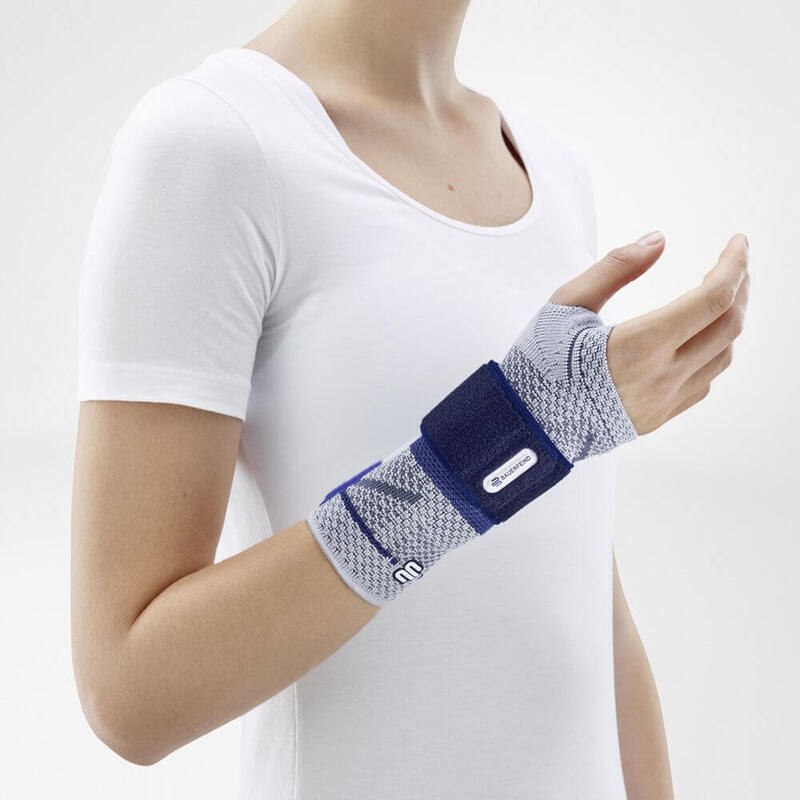 ManuTrain (Titan) Using One Strap Image of the side of Bauerfeind's ManuTrain wrist brace while being worn by a person in front of a gray background.
