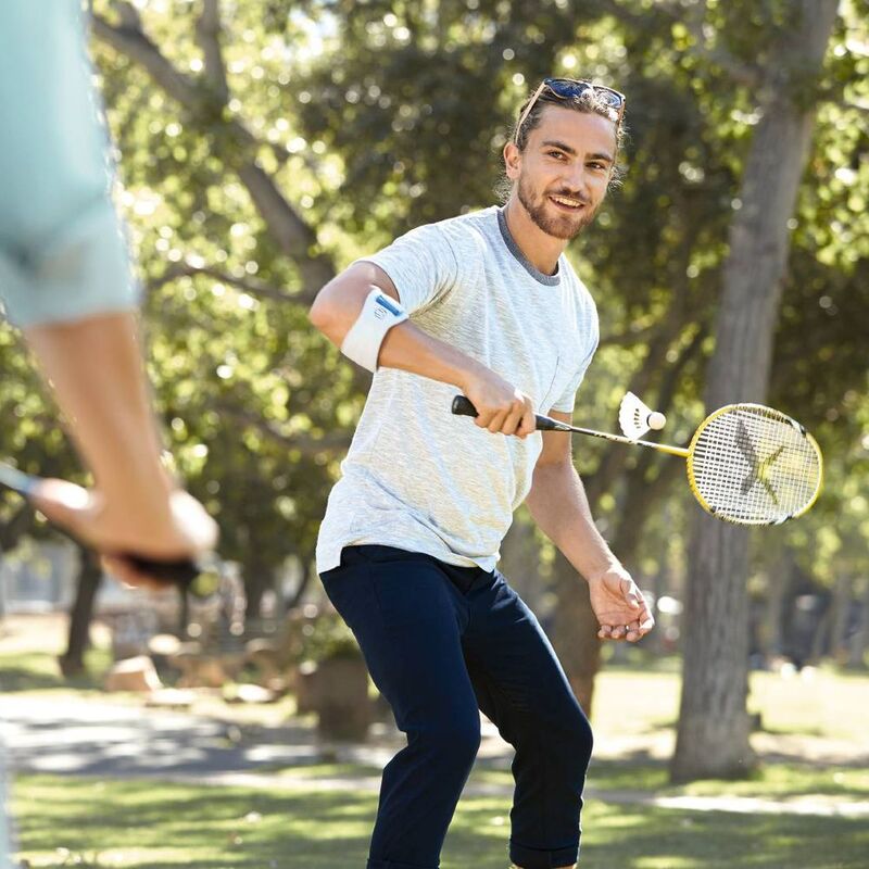 Man wearing the EpiPoint while playing badminton. Image of a man wearing Bauerfeind's EpiPoint elbow strap while playing badminton.