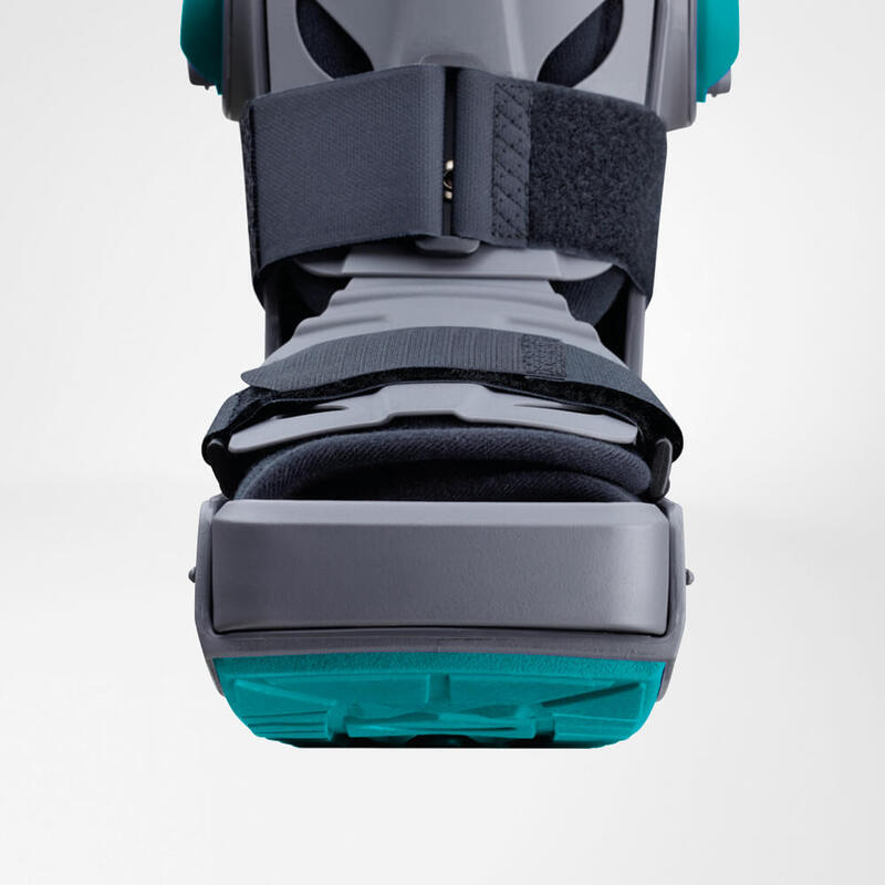 Innovative Walker Boot for Enhanced Mobility and Support Close-up view of a modern, gray and turquoise knee brace highlighting its adjustable straps and sturdy support mechanism.