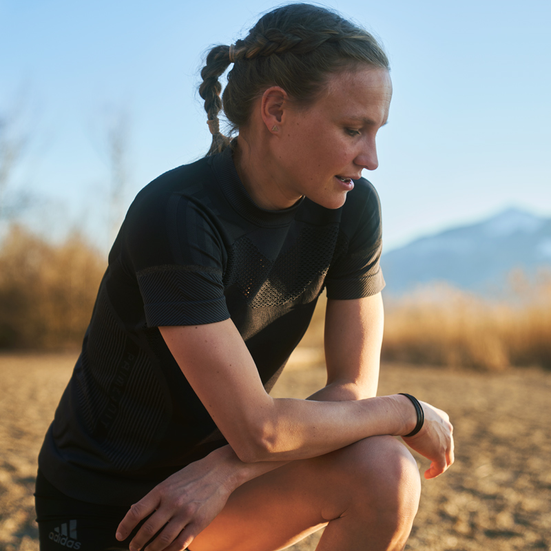 Woman bending down to rest during a run.