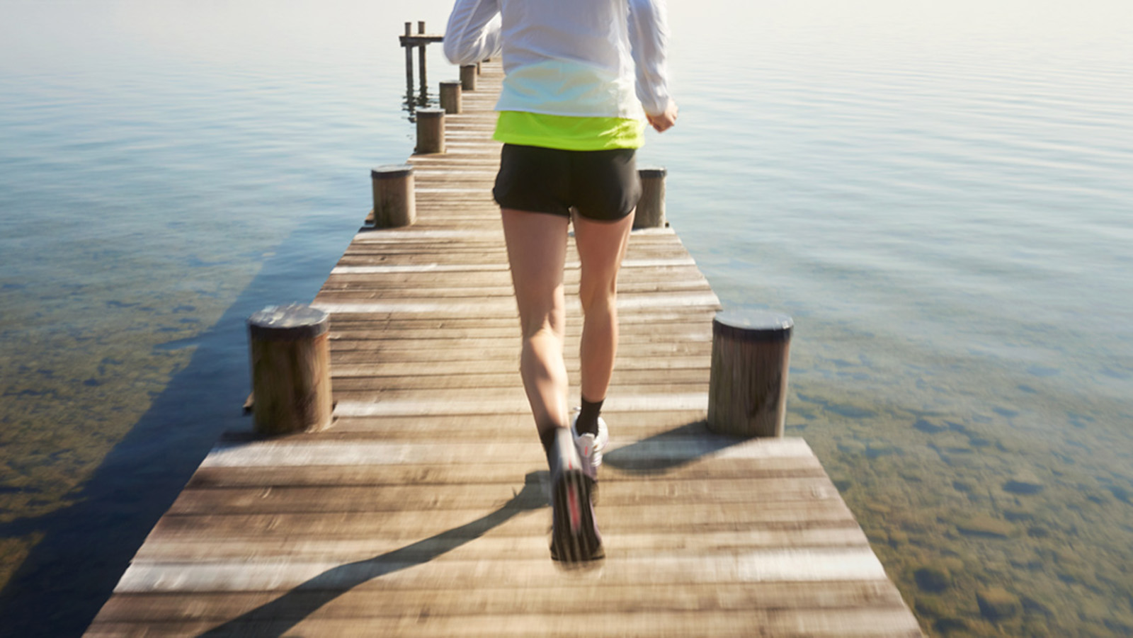 How to Prevent Sore Knees While Running Woman running on a dock.