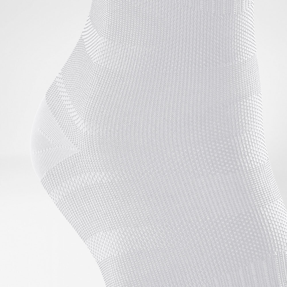 Close-up of white knitted fabric texture showcasing intricate patterns.