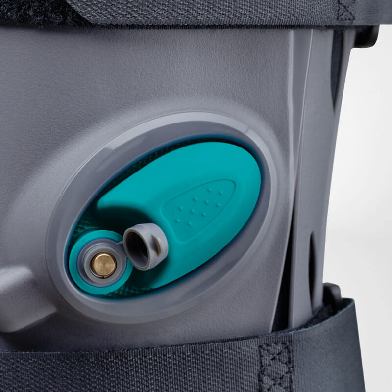 Innovative Walker Boot for Enhanced Mobility and Support Close-up view of a modern, gray and turquoise knee brace highlighting its adjustable straps and sturdy support mechanism.