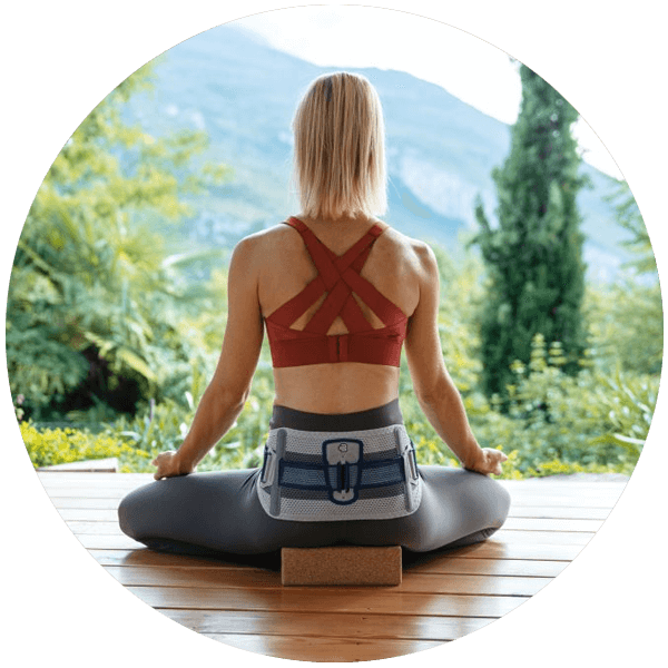Comfortable to Wear Person wearing Bauerfeind's SacroLoc SI joint belt while sitting outdoors to practice yoga.