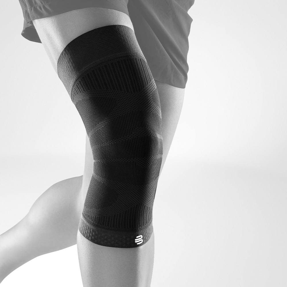 Person wearing a black knee sleeve for support and compression