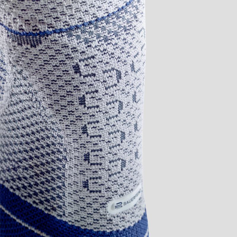 Blue and White Ankle Brace for Injury Recovery and Support Close-up view of a person wearing a blue and white ankle support brace demonstrating its fit and design on a neutral background