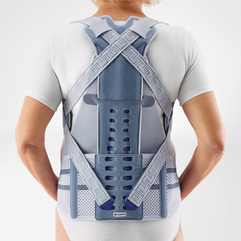 Effective Back Pain Relief with Modern Lumbar Support Brace Middle-aged woman adjusting her modern lumbar support brace looking into a mirror in a brightly lit room.