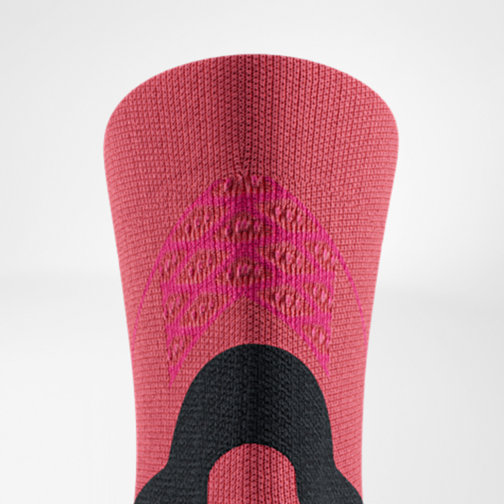 Close, posterior view of the coral Run Performance Mid-Cut Socks.