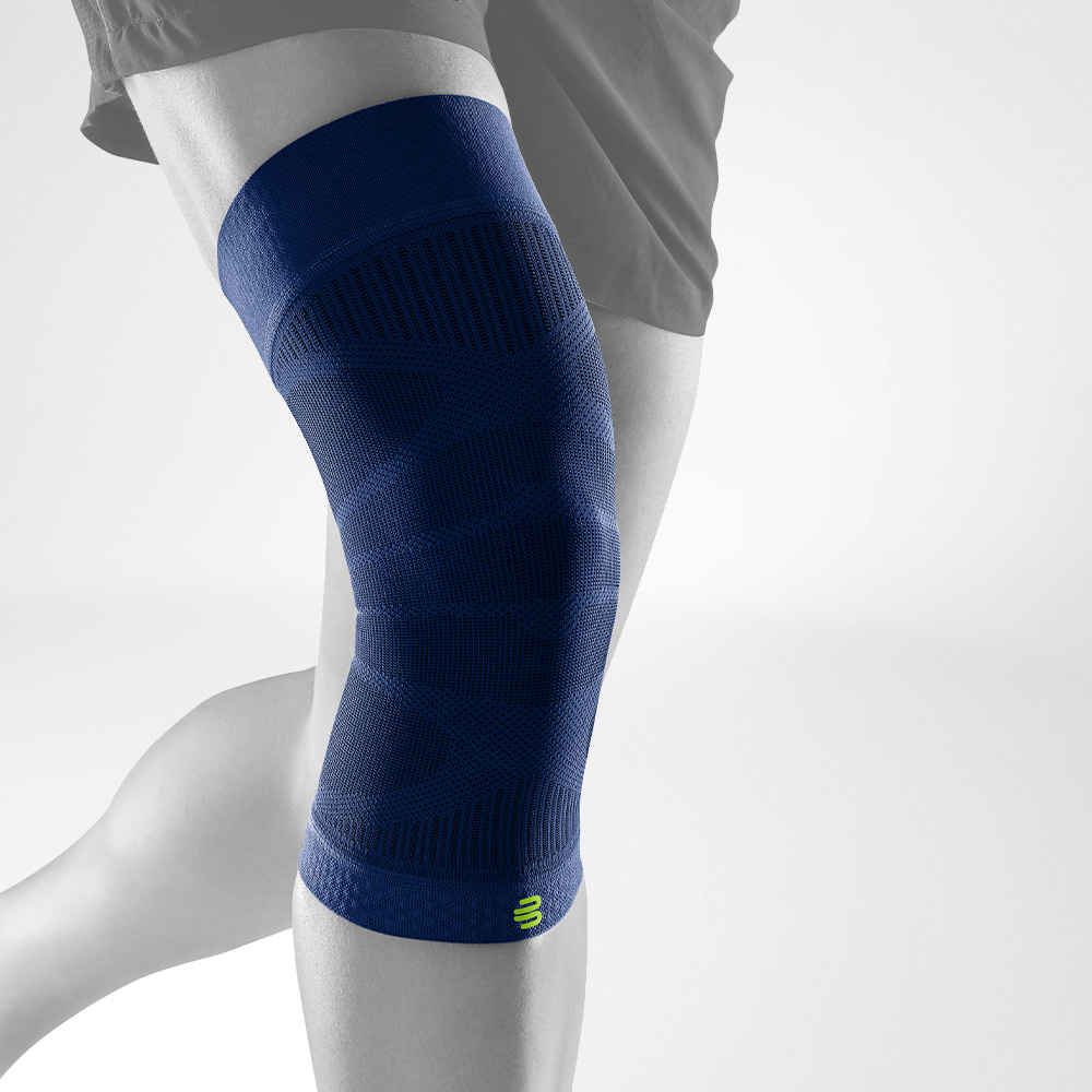 Person wearing a teal blue knee compression sleeve for support and recovery.