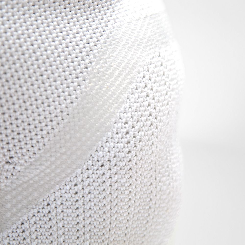 Detailed view of white knitted fabric with a wave design Close-up of white textured fabric with a unique wave pattern
