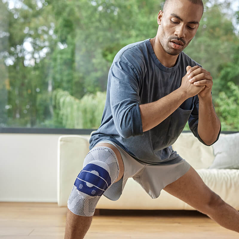 Man wearing Bauerfeind's GenuTrain knee brace while exercising.