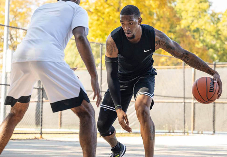 Shooting a basketball while wearing Bauerfeind's Sports Compression Arm Sleeves.