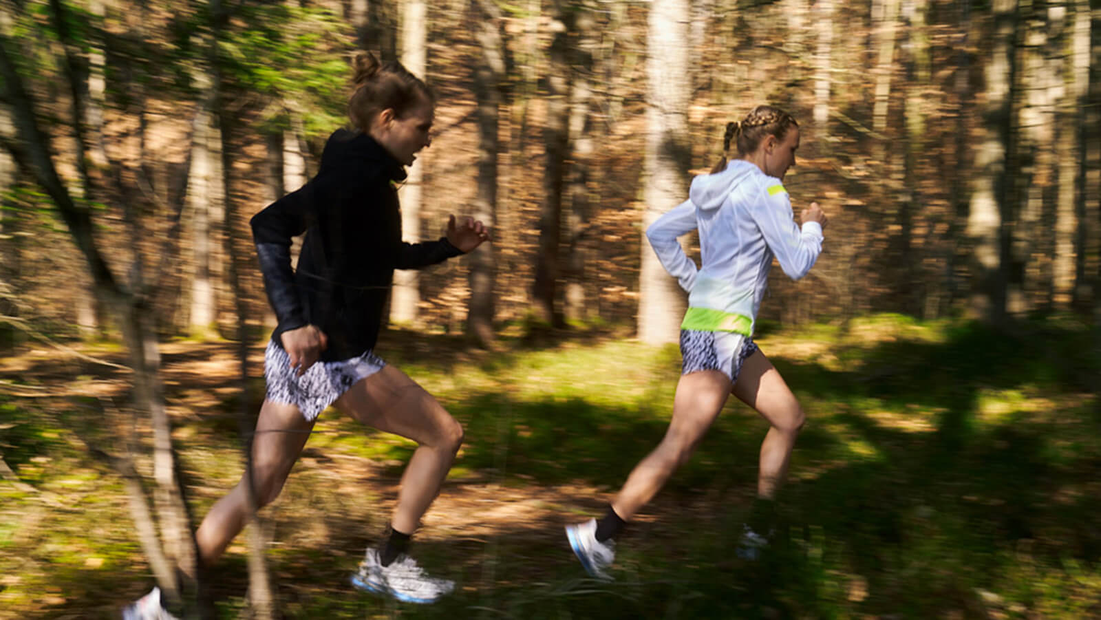 Anna and Lisa Hahner Two women running through a lakeside trail while wearing Bauerfeind braces and compression wear.
