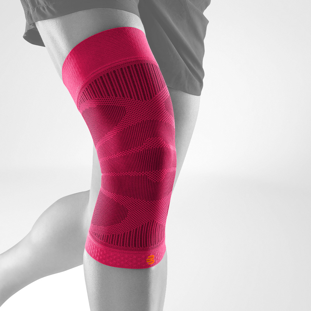 Person wearing a teal blue knee compression sleeve for support and recovery.
