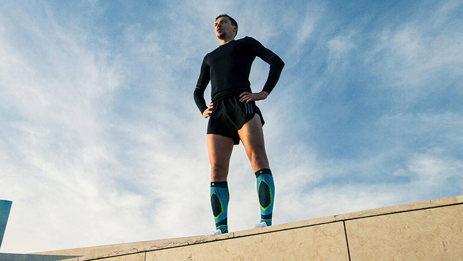 Man overlooking a city before a morning run while wearing the Run Performance Compression Socks. Man overlooking a city before a morning run while wearing Bauerfeind's Run Performance Compression Socks.