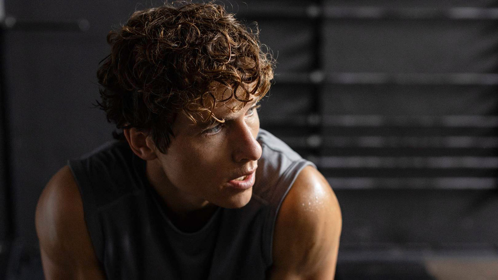 Man resting in the middle of workout. Image of man taking a break in the middle of working out at a fitness center.