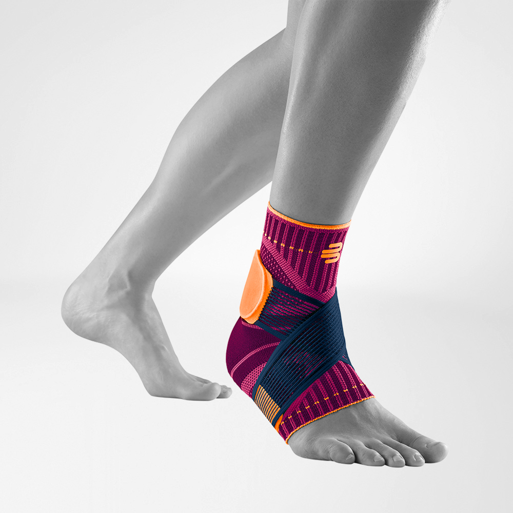 Front-side view of the Sports Ankle Support pink on a grey foot