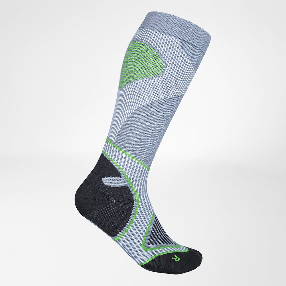 Close-up of a sporty green and yellow striped running sock on a foot, highlighting its breathable fabric and ergonomic design